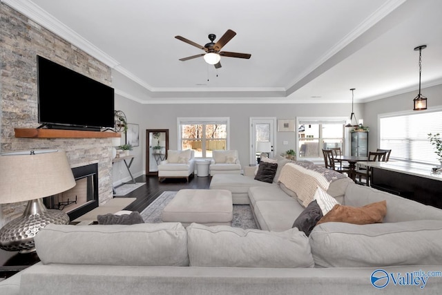 living room featuring ceiling fan, a fireplace, ornamental molding, and hardwood / wood-style flooring