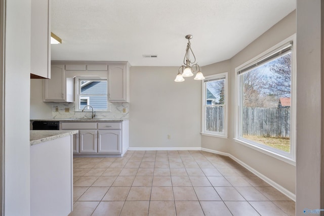 kitchen with visible vents, backsplash, baseboards, light tile patterned floors, and a sink