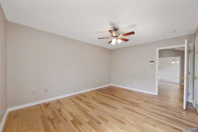 empty room with a ceiling fan, light wood-style floors, and baseboards