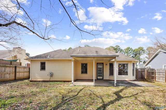 rear view of house featuring a patio area, a lawn, and a fenced backyard