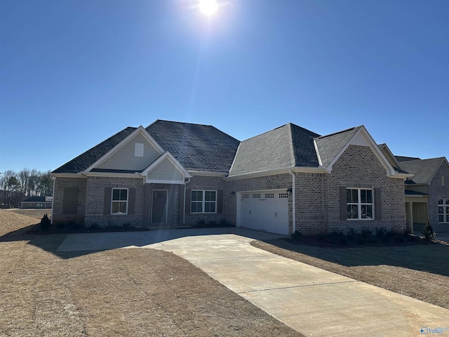 view of front facade with a garage, driveway, brick siding, and roof with shingles