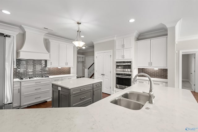 kitchen featuring sink, hanging light fixtures, backsplash, and custom exhaust hood