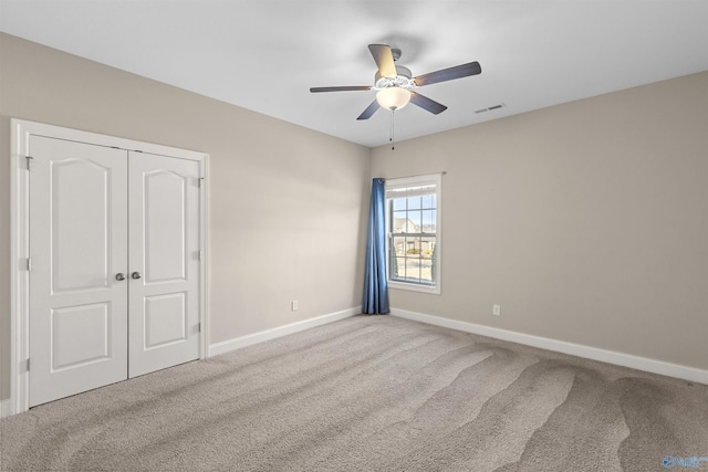 unfurnished bedroom featuring ceiling fan, a closet, and carpet