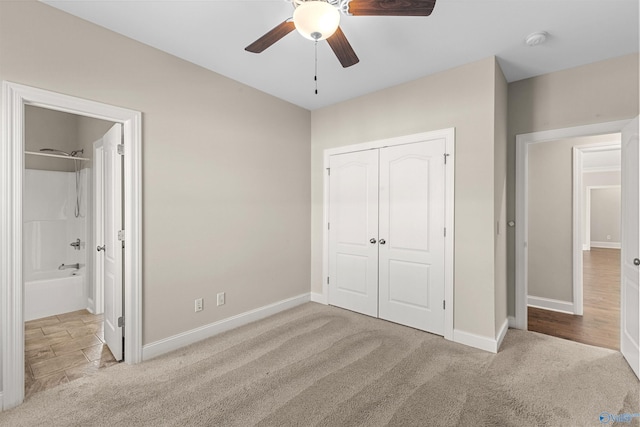 unfurnished bedroom with connected bathroom, ceiling fan, a closet, and light colored carpet