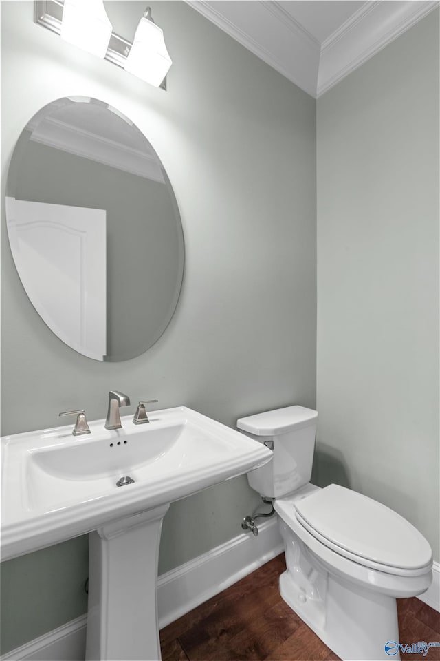 bathroom with toilet, crown molding, wood-type flooring, and sink