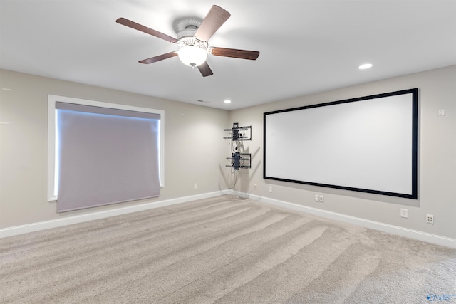 home theater room featuring ceiling fan and light carpet