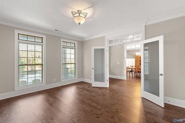 unfurnished room featuring an inviting chandelier, dark hardwood / wood-style flooring, crown molding, and french doors