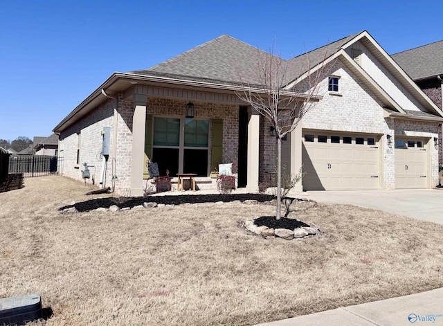 view of front of house featuring brick siding, a shingled roof, fence, a garage, and driveway