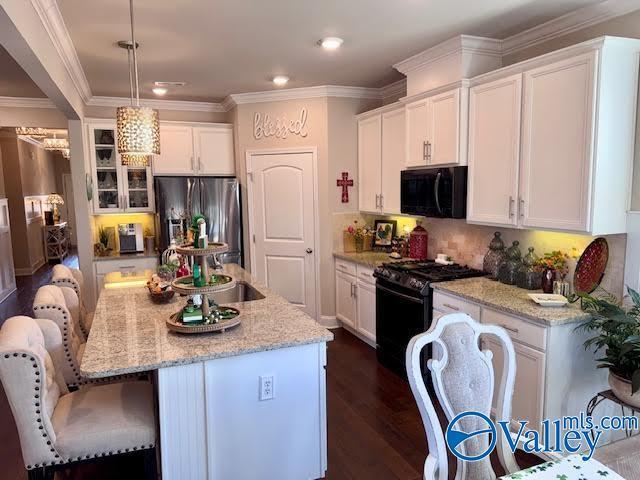 kitchen featuring white cabinetry, black appliances, and ornamental molding