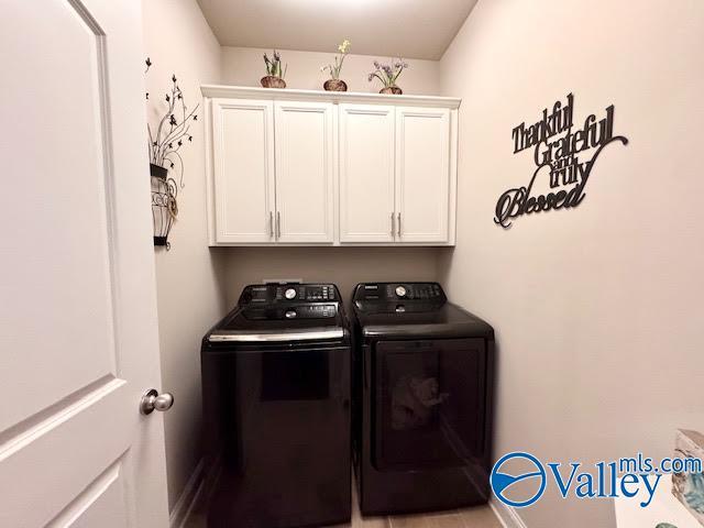 washroom with washing machine and dryer and cabinet space