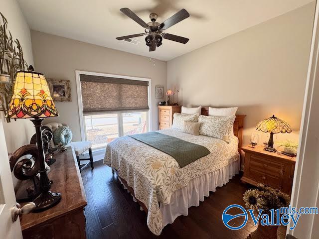 bedroom featuring visible vents, dark wood-style floors, and a ceiling fan