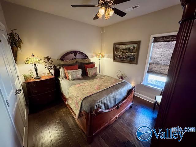 bedroom with hardwood / wood-style floors, a ceiling fan, visible vents, and baseboards