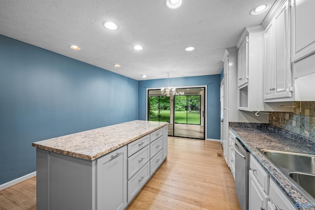 2211 Pumpkin Center Rd NE, Fort Payne, AL 35967 - kitchen featuring dishwasher, a kitchen island, baseboards, a chandelier, and light wood-style flooring