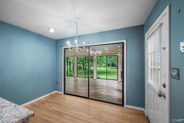 2211 Pumpkin Center Rd NE, Fort Payne, AL 35967 - unfurnished dining area with a chandelier, light wood-style floors, baseboards, and a textured ceiling