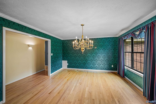 2211 Pumpkin Center Rd NE, Fort Payne, AL 35967 - spare room featuring wood finished floors, ornamental molding, a chandelier, a textured ceiling, and wallpapered walls