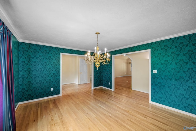 2211 Pumpkin Center Rd NE, Fort Payne, AL 35967 - empty room featuring a chandelier, light wood-type flooring, wallpapered walls, baseboards, and crown molding
