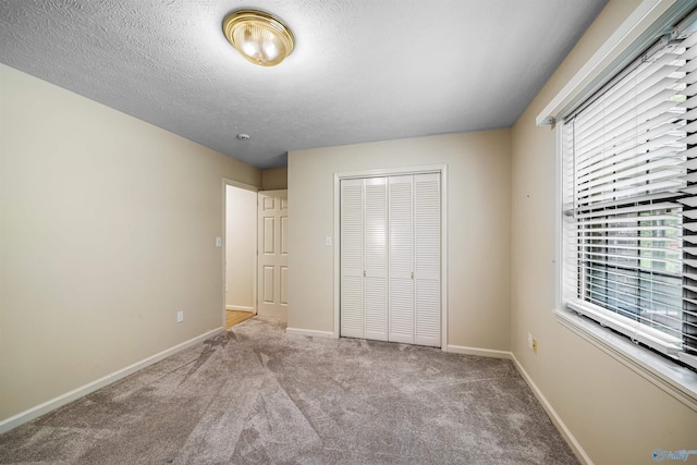 2211 Pumpkin Center Rd NE, Fort Payne, AL 35967 - unfurnished bedroom featuring multiple windows, a closet, baseboards, carpet floors, and a textured ceiling