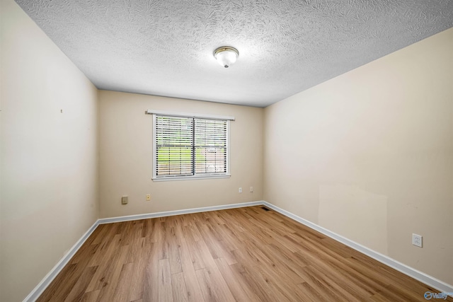 2211 Pumpkin Center Rd NE, Fort Payne, AL 35967 - empty room with light wood-style flooring, baseboards, and a textured ceiling