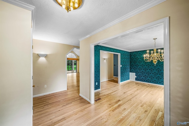 2211 Pumpkin Center Rd NE, Fort Payne, AL 35967 - empty room featuring a chandelier, crown molding, wood finished floors, baseboards, and wallpapered walls