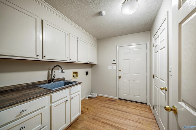 2211 Pumpkin Center Rd NE, Fort Payne, AL 35967 - laundry room with hookup for an electric dryer, cabinet space, washer hookup, light wood-style floors, and baseboards