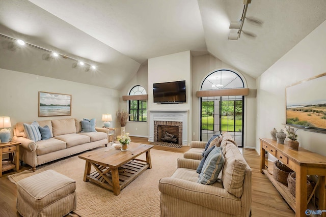 2211 Pumpkin Center Rd NE, Fort Payne, AL 35967 - living room with light wood-style flooring, track lighting, a fireplace, and high vaulted ceiling