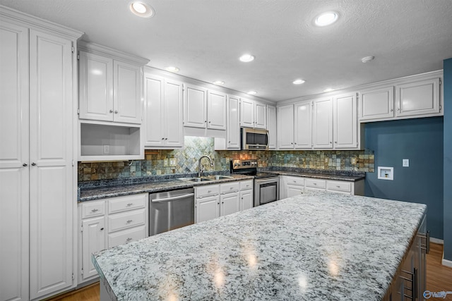 2211 Pumpkin Center Rd NE, Fort Payne, AL 35967 - kitchen featuring stainless steel appliances, a sink, wood finished floors, white cabinets, and recessed lighting