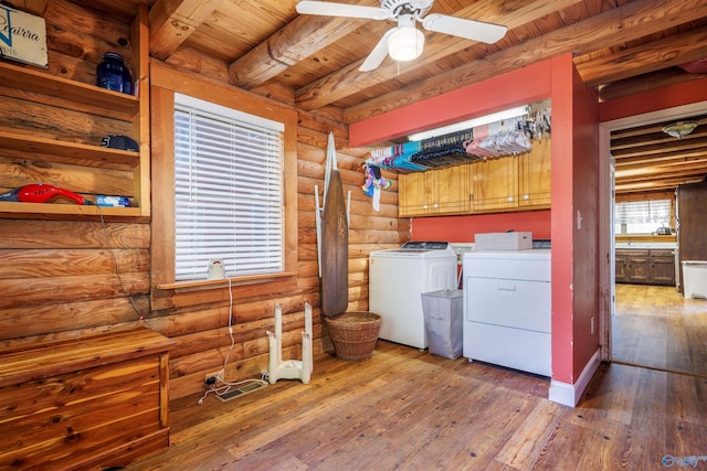 clothes washing area featuring cabinets, wood ceiling, washer and dryer, hardwood / wood-style flooring, and rustic walls