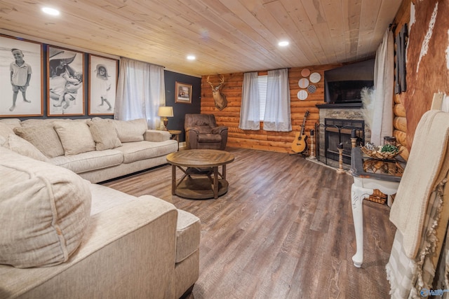 living room with log walls, hardwood / wood-style floors, a stone fireplace, and wooden ceiling