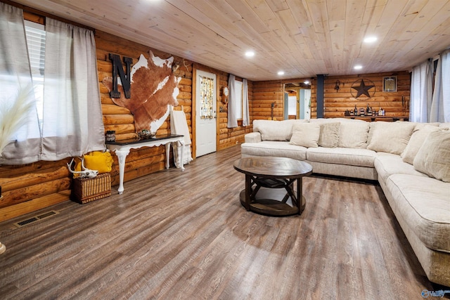 living room with log walls, hardwood / wood-style flooring, and a wealth of natural light