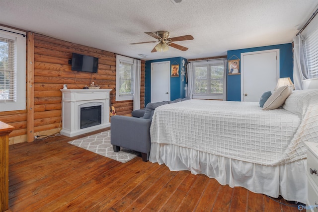 bedroom with multiple windows, wood-type flooring, and ceiling fan