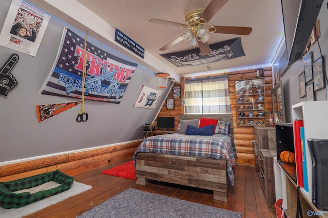 bedroom with dark wood-type flooring, a textured ceiling, and ceiling fan