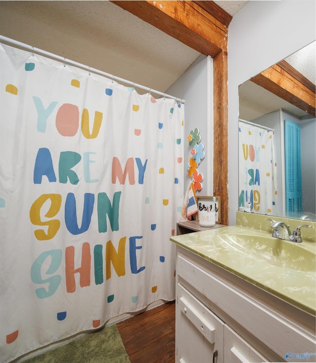 bathroom featuring vanity, hardwood / wood-style floors, a textured ceiling, and a shower with shower curtain