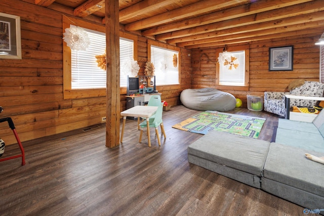 bedroom with dark wood-type flooring, a notable chandelier, beamed ceiling, and rustic walls