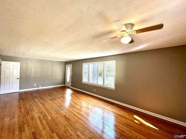 unfurnished room featuring hardwood / wood-style flooring, ceiling fan, and a textured ceiling