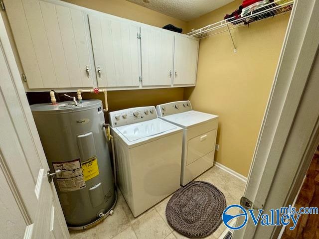 laundry room with cabinets, electric water heater, independent washer and dryer, light tile patterned floors, and a textured ceiling