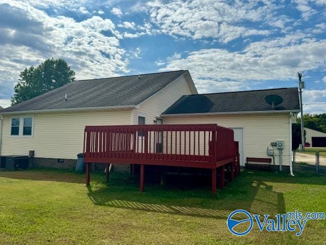 back of property featuring a wooden deck and a lawn