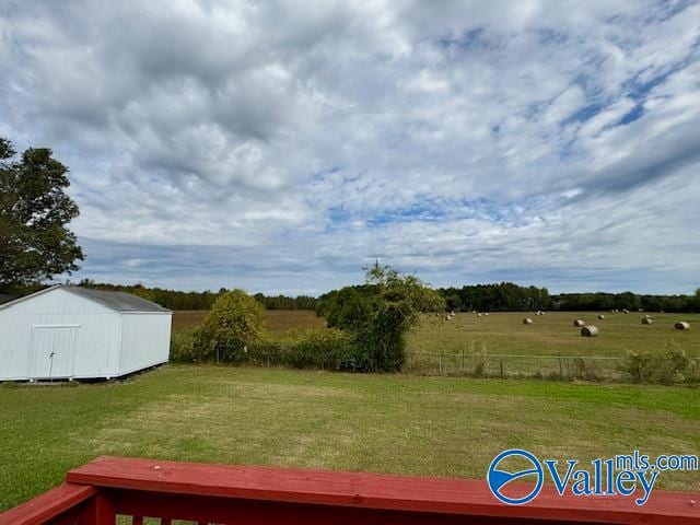 view of yard with a rural view and a storage shed