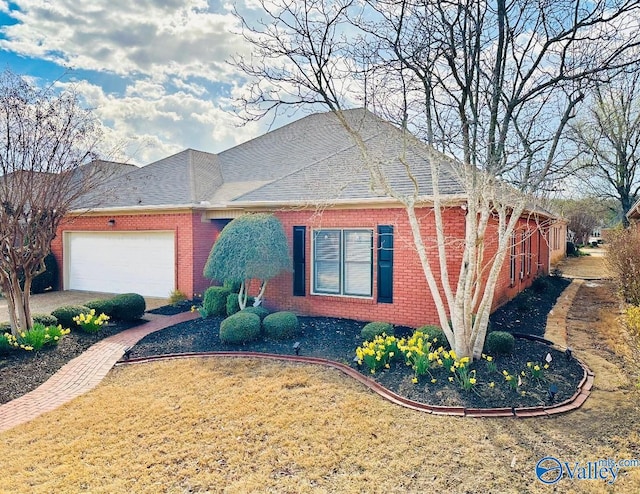 ranch-style house with an attached garage, brick siding, and a shingled roof