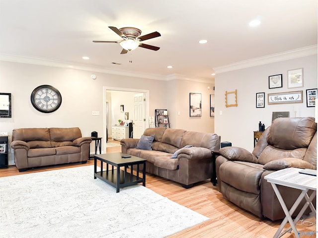 living room with light wood-style floors, a ceiling fan, and crown molding