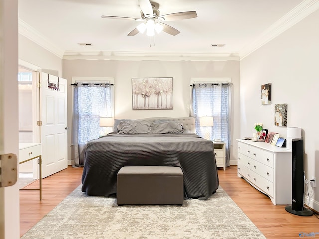 bedroom with multiple windows, crown molding, and light wood-type flooring