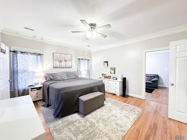 bedroom with a ceiling fan, visible vents, baseboards, crown molding, and light wood-type flooring