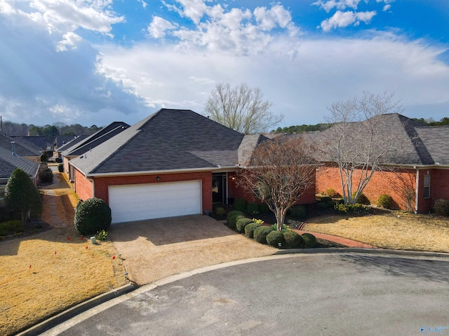 ranch-style house featuring driveway, brick siding, an attached garage, and a shingled roof