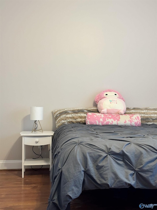 bedroom featuring baseboards and wood finished floors