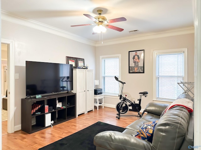 living area with visible vents, wood finished floors, a ceiling fan, and crown molding