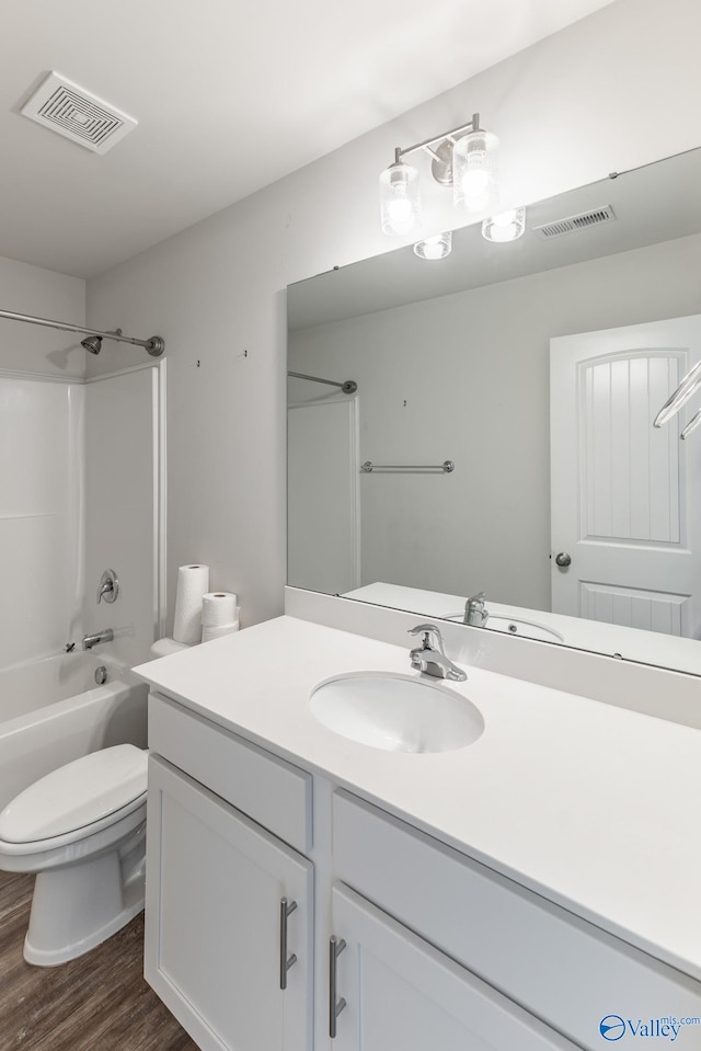 full bathroom featuring hardwood / wood-style floors, vanity, toilet, and tub / shower combination