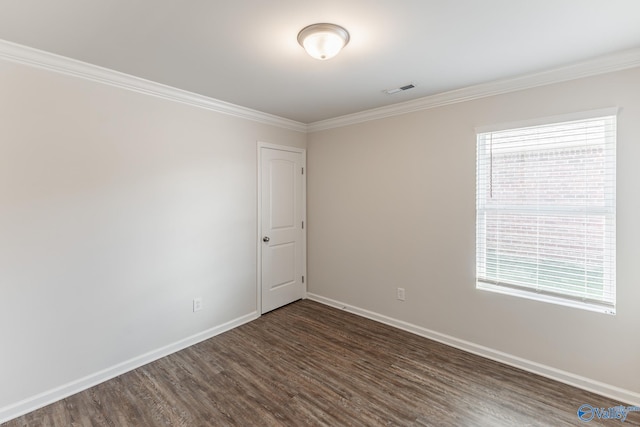 empty room featuring dark hardwood / wood-style floors and crown molding