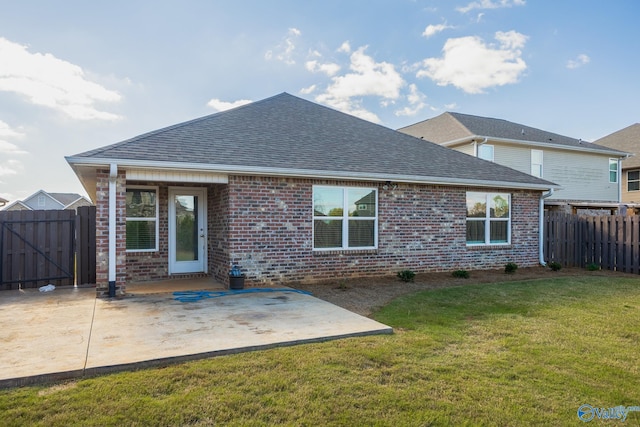 back of house featuring a lawn and a patio area