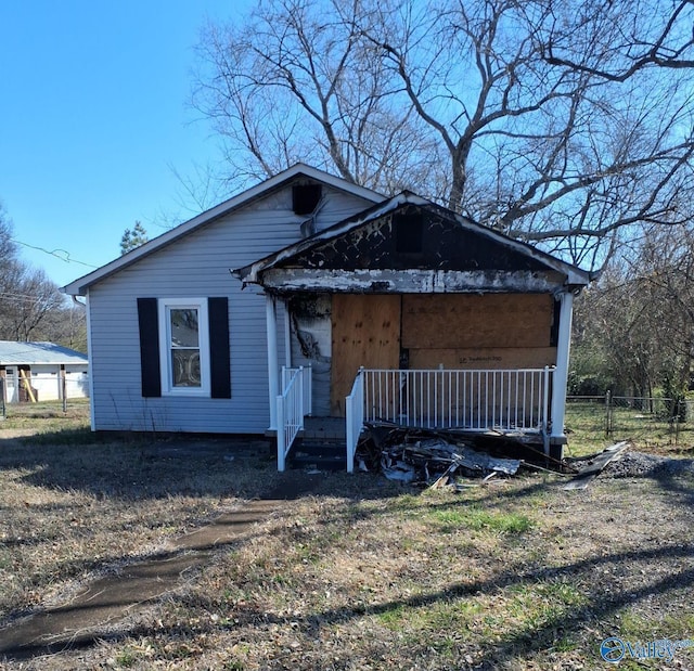 view of front facade featuring covered porch and fence