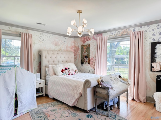 bedroom with wallpapered walls, visible vents, multiple windows, and a notable chandelier