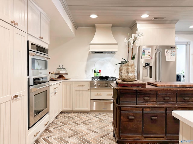 kitchen with a warming drawer, light countertops, premium range hood, appliances with stainless steel finishes, and recessed lighting